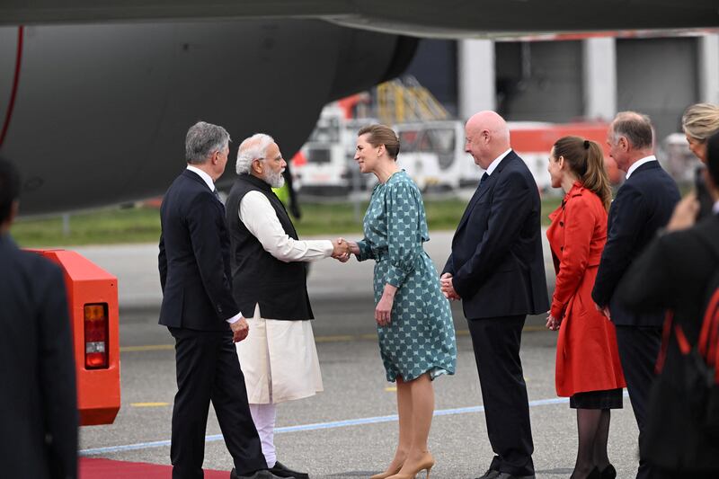 Ms Frederiksen and Denmark's ambassador to New Delhi Freddy Svane receive Mr Modi at Copenhagen Airport. Reuters