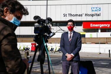 Members of the media wearing protective face masks broadcast from outside St Thomas' Hospital in London. Bloomberg