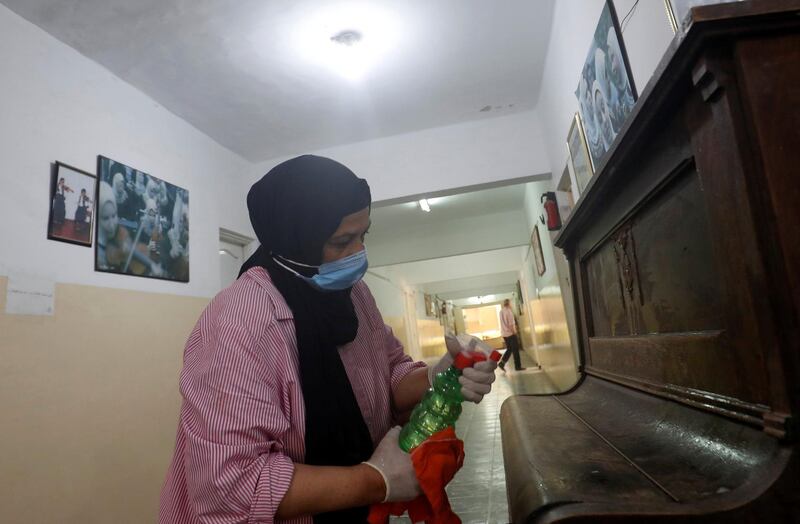 An Egyptian woman wearing a protective face mask sprays antiseptic, amid the coronavirus pandemic in Cairo, Egypt. Reuters