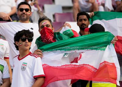 Iranian football fans display a flag with the middle symbol sliced out before the England and Iran match at the Khalifa International Stadium in in Doha, Qatar. AP