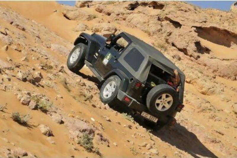 A Jeep Wrangler tries to scramble up the rocky passage at Kharn Murrah while a rear passenger clings on for dear life.