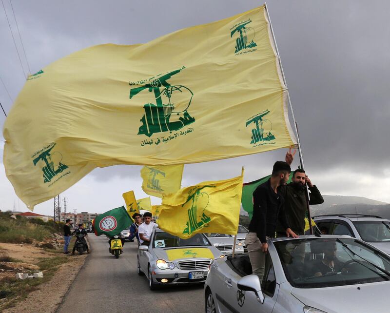 A supporter of Lebanon's Hezbollah gestures as he holds a Hezbollah flag in Marjayoun.  Aziz Taher / Reuters