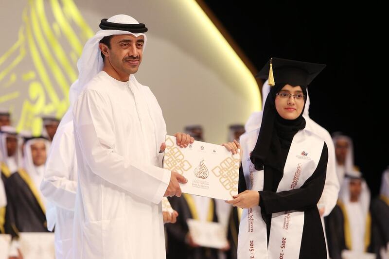 Sheikh Abdullah bin Zayed, Minister of Foreign Affairs and International Co-operation, gives an award to Hajar Al Ktefan, who achieved the highest mark for a young woman in public school Grade 12 exams. Pawan Singh / The National 
