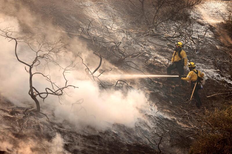 A firefighter uses a hose as the Silverado Fire approaches, near Irvine, California, U.S. October 26, 2020. REUTERS