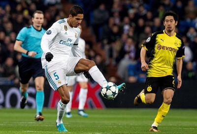 epa06372299 Real Madrid's French defemder Raphael Varane (L) vies for the ball with Borussia Dortmund's Japanese striker Shinji Kagawa during the UEFA Champions League 6th round groups phase match between Real Madrid and Borja Mayoral at the Santiago Berbabeu stadium in Madrid, Spain, 06 December 2017.  EPA/Rodrigo Jimenez