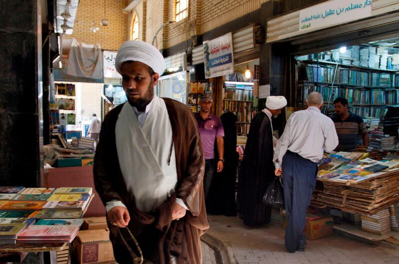 Iraqis check books at the Howeish book market in the holy city of Najaf, 150 kilometres (95 miles) south of Baghdad, on August 16, 2018.
 In the covered alleyways of old Najaf in Iraq, poetry and philosophy books compete with economic treatises, the Koran and other theological tomes for students' attention. / AFP / Haidar HAMDANI
