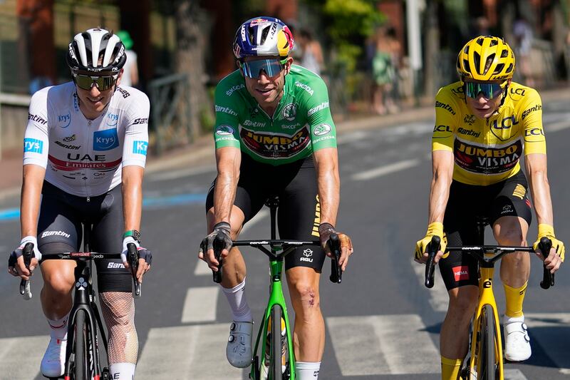 Jonas Vingegaard, wearing the overall leader's yellow jersey and who also has the best climber's dotted jersey, Wout van Aert, wearing the best sprtinters green jersey, and Tadej Pogacar, wearing the best young rider's white jersey. AP