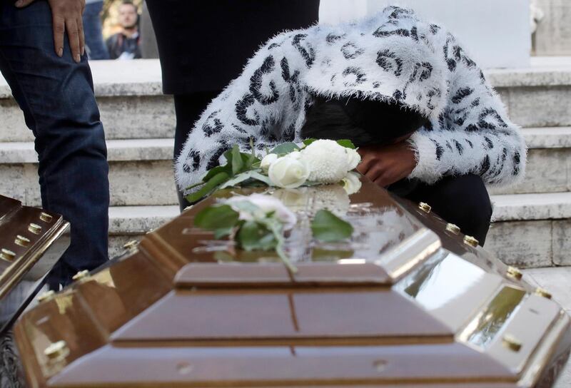 A woman cries by a coffin during the funeral service for 26 Nigerian women who died trying to cross the Mediterranean Sea,  at the Salerno cemetery, southern Italy. Alessandra Tarantino / AP Photo