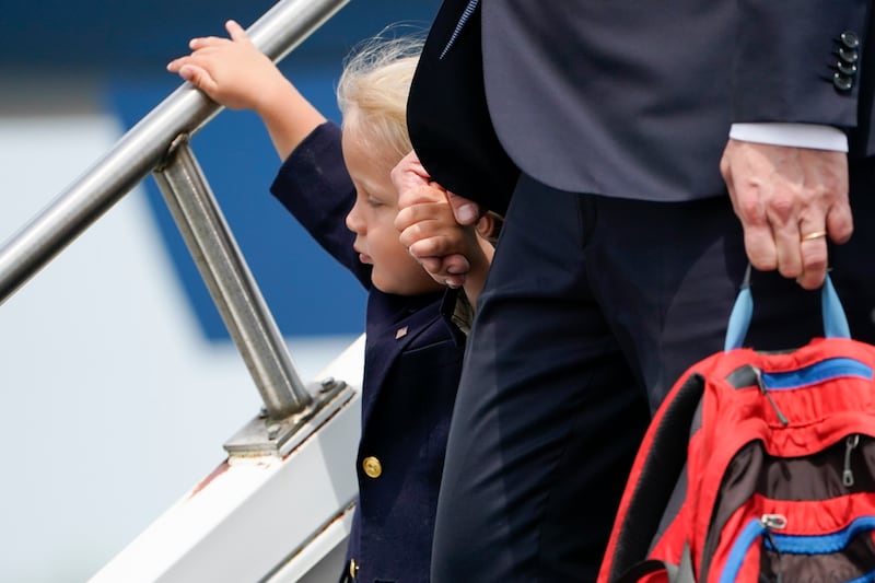 Hunter Biden holds his son Beau's hand as they walk down the steps of the aircraft. AP