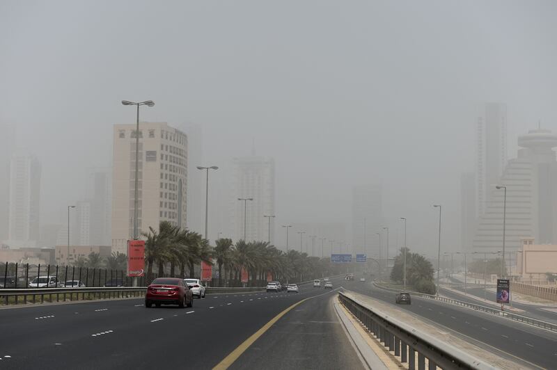 Cars drive on the main highway during a dust storm in the Bahraini capital Manama. AFP