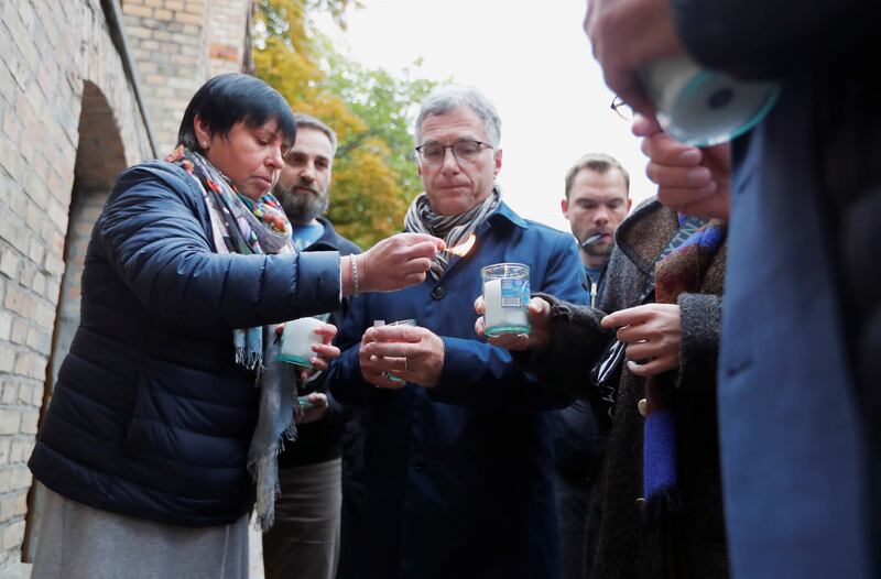 People light candles outside the synagogue in Halle a day after it was attacked. Reuters