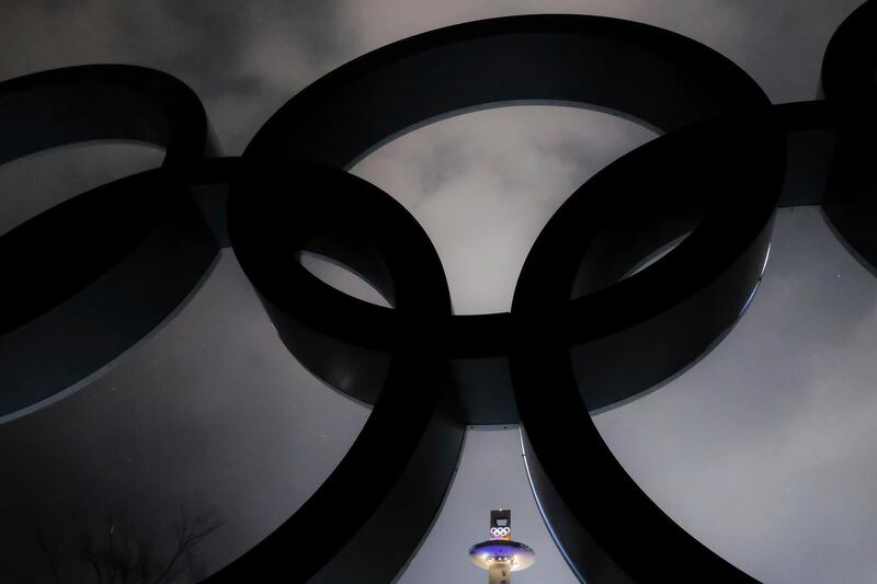 The ski jumping tower is framed in the Olympic Rings on a storming night at the 2018 Winter Olympics in Pyeongchang, South Korea. J David Ake / AP Photo