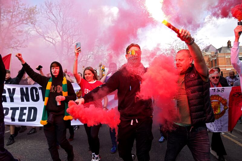 Manchester United fans wave flares in a protest against the team's ownership before the Premier League match at Old Trafford against Norwich on April 16. PA