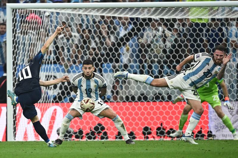 Croatia's midfielder #10 Luka Modric attempts a shot at goal as Argentina's defender #19 Nicolas Otamendi and Argentina's midfielder #20 Alexis Mac Allister try to block him. AFP