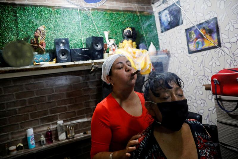 A woman conducts a spiritual cleansing on a client looking to improve her health and her economic situation due to the coronavirus outbreak, at the Sonora market, in Mexico City, Mexico. Reuters