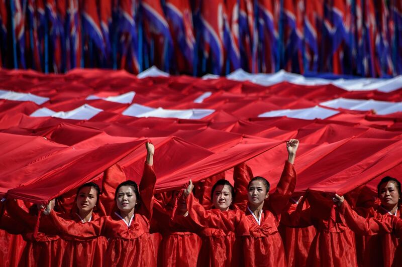 Participants march past a balcony from where North Korea's leader Kim Jong Un was watching, during a mass rally on Kim Il Sung square in Pyongyang.  AFP