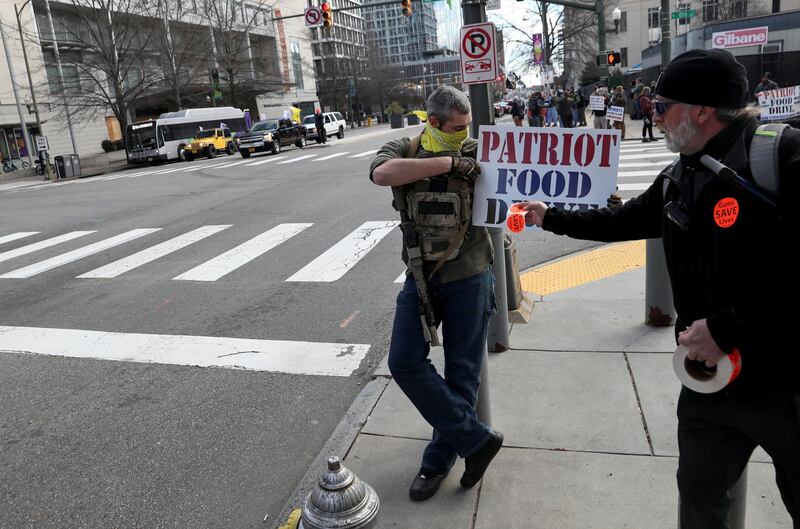 Stickers reading "Guns save lives" are put on a food drive sign as armed people stand on a corner near the Virginia State Capitol while a caravan of cars drives by in support of second amendment rights, in Richmond, Virginia, U.S. January 18, 2021. REUTERS/Leah Millis
