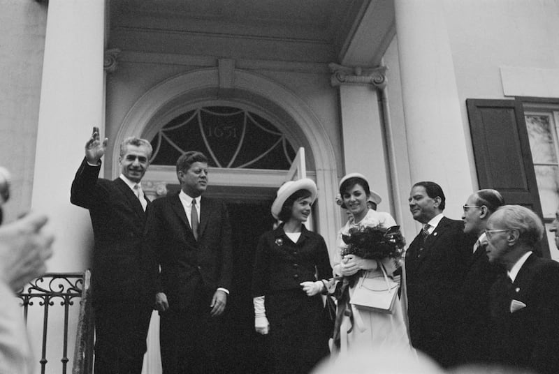 The Shah waves to journalists after he and Empress Farah, accompanied by President and first lady Jackie Kennedy, arrived at the Blair House, in Washington, during a state visit in April 1962. Getty Images