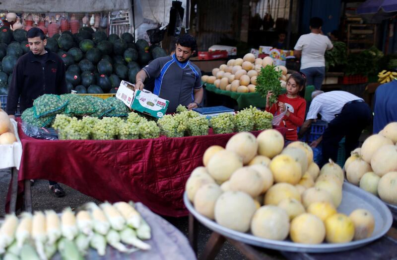 People shop as a vendor sells fruits and vegetables in a market as Palestinians ease restrictions at the Beach refugee camp in the occupied Gaza City. Reuters