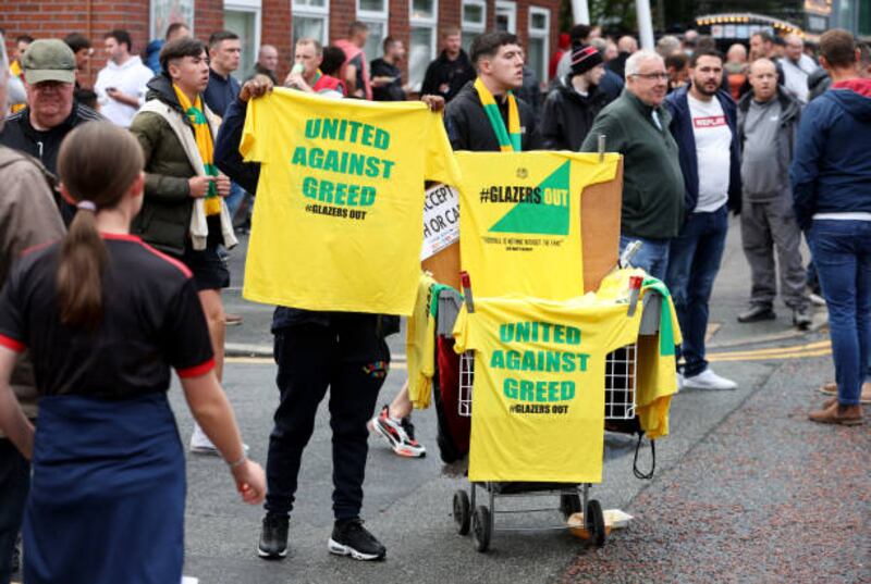 MANCHESTER, ENGLAND - AUGUST 22: Shirts protesting about the Glazer ownership of Manchester United are sold outside the stadium. Getty