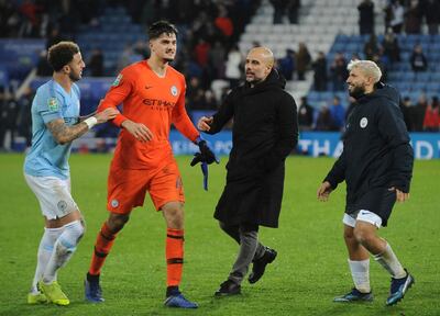 Manchester City's goalkeeper Arijanet Muric, centre celebrates in font of their fans with Manchester City's manager Pep Guardiola, second right, Manchester City's Kyle Walker, left and Manchester City's Sergio Aguero during the English League Cup quarterfinal soccer match at the King Power stadium in Leicester, England, Tuesday, Dec.18, 2018. Manchester City won 3-1 in a penalty shoot out after the match ended in a 1-1 draw in normal time. (AP Photo/Rui Vieira)