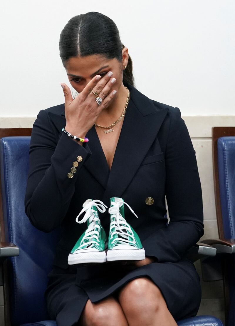 Camila Alves McConaughey, a model, designer and the wife of actor Matthew McConaughey, holds a pair of sneakers used to identify one of the student victims. Reuters