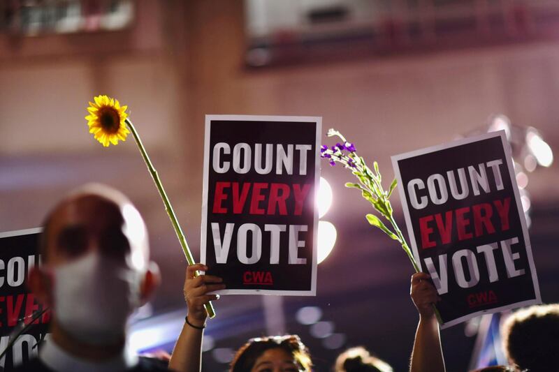 Activists hold up flowers and signs stating "count every vote". Philadelphia, Pennsylvania. Reuters