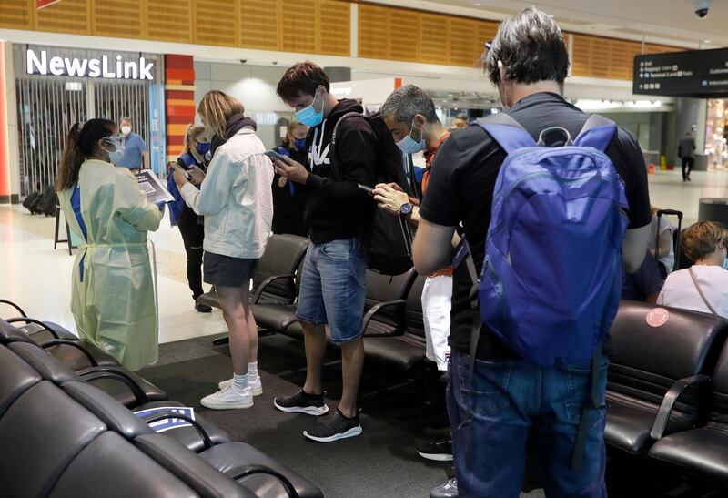 Passengers arriving from Melbourne are screened  by health workers at the airport in Sydney, Australia, on nFebruary 12, 2021. AP Photo