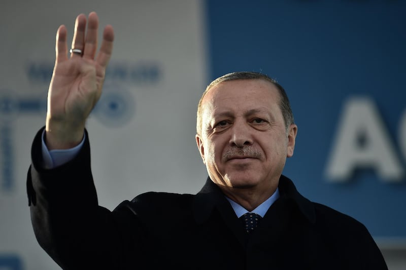 Turkish President Recep Tayyip Erdogan makes a four-finger (rabia) sign during his speech on December 15, 2017 in Istanbul during the inauguration ceremony of Turkey's first automated urban metro line on the Asian side of Istanbul.  / AFP PHOTO / OZAN KOSE