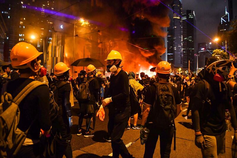 Protesters stand before a barricade they set on fire in the Wan Chai district in Hong Kong. AFP