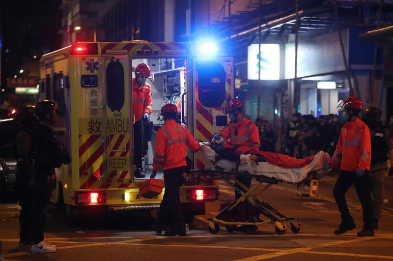 Medical team carry a man to an ambulance during a protest in Mong Kok, Hong Kong. AP Photo