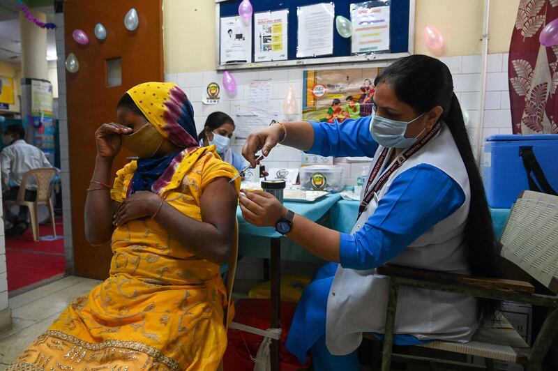 A health worker inoculates a woman with a dose of the Covaxin vaccine in New Delhi. Prakash Singh / AFP