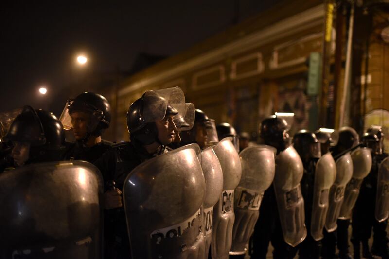 Riot police line up behind their shields following a clash with demonstrators demanding the resignation of congressmen outside the Guatemalan National Congress, in Guatemala City. Guatemala's congress early this week voted overwhelmingly to reject a UN-backed request to lift the immunity of President Jimmy Morales, in order for him to face a corruption probe over irregular party financing. Johan Ordonez / AFP Photo.