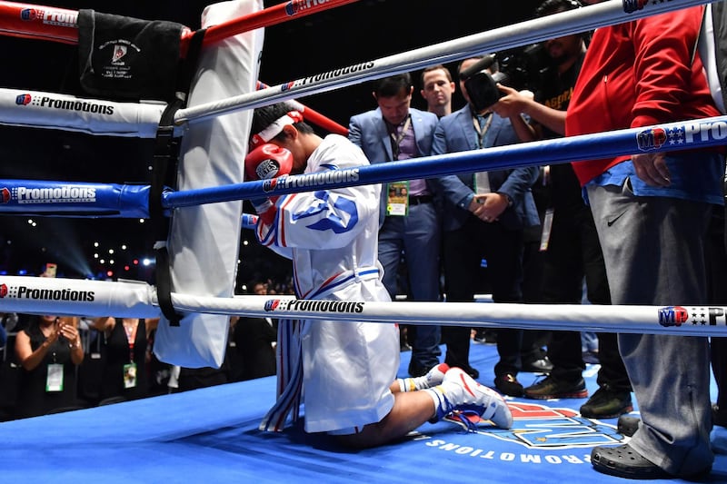 Manny Pacquiao prays before his world welterweight boxing championship bout against Argentina's Lucas Matthysse at Axiata Arena in Kuala Lumpur. AFP