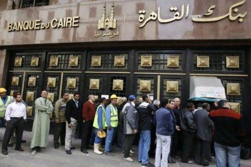 People stand in the line to make withdrawals outside Cairo Bank in downtown Cairo.