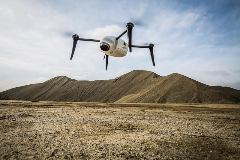In this undated photo provided by Kespry, a Kespry drone hovers prior to measuring stockpiles at an aggregate site. Robots are coming to a construction site near you. Tech startups are developing self-driving bulldozers, survey drones and bricklaying robots to help the construction industry boost productivity, speed and safety as it struggles to find enough skilled workers. (Adam Crowley/Kespry via AP)