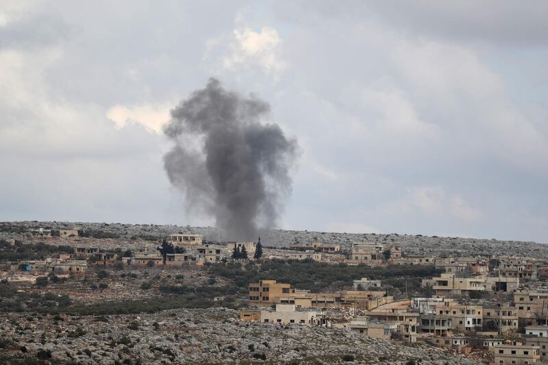 A picture taken on February 23, 2020, shows smoke billowing in a town in the Jabal al-Zawiya region in the northern countryside of Syria's Idlib province. / AFP / Omar HAJ KADOUR
