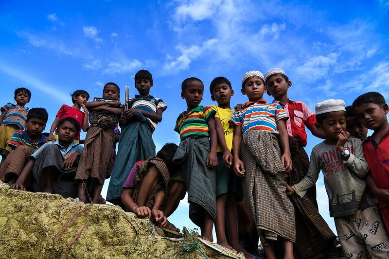 Rohingya refugee children look on at the Kutupalong camp in Ukhia near Cox's Bazar on August 12, 2018. - Nearly 700,000 Rohingya fled Myanmar's Rakhine state last year to escape a violent military crackdown. The United Nations has described the army purge against the persecuted minority as ethnic cleansing, and thousands of Rohingya Muslims were believed to have been slaughtered in the pogrom that began last August. (Photo by CHANDAN KHANNA / AFP)