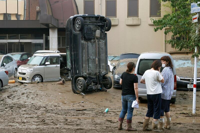 A car stands vertically on a muddy road after being washed away by flood, in Hitoyoshi, Kumamoto prefecture, southwestern Japan. AP