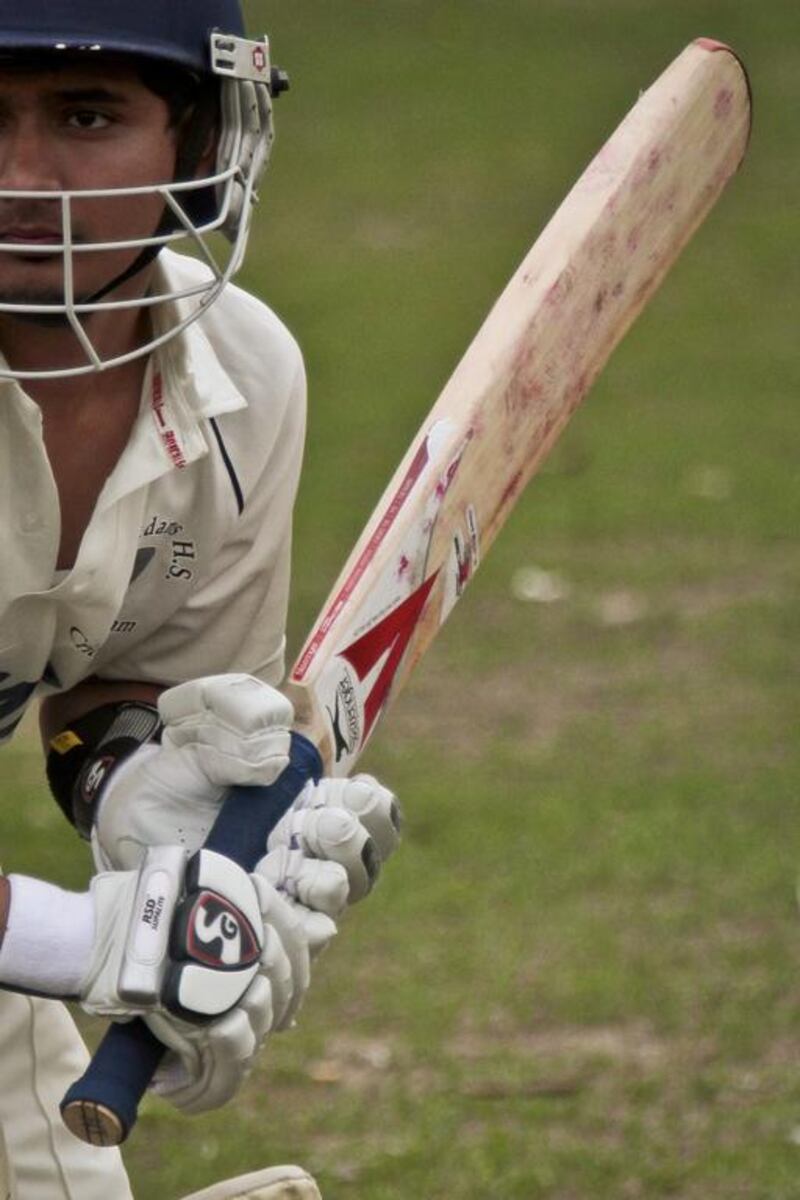 In this May 12, 2014 photo, John Adams High School batsman Tazul Uddin raises his bat during a warm-up before playing against Midwood High School in a match between New York City public schools as participation in cricket grows in the US thanks to America's large immigrant populations. Bebeto Matthews / AP
