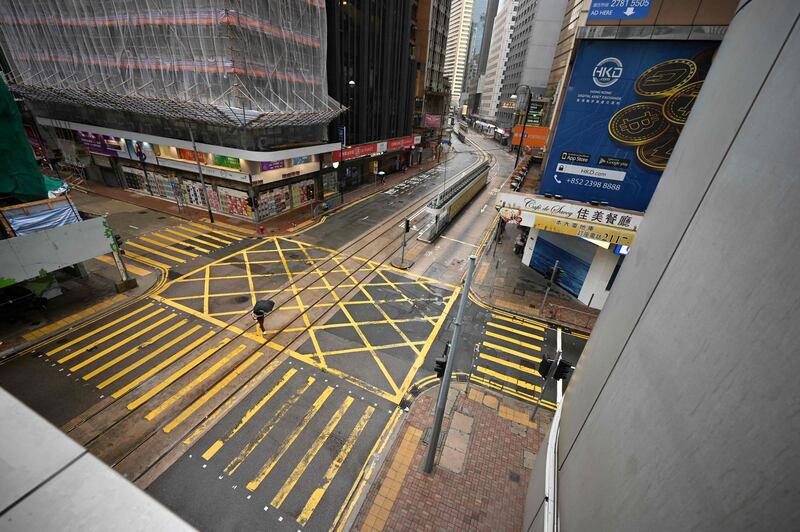 A pedestrian crosses an empty street in Hong Kong's central business district. The world’s toughest Covid-19 travel and quarantine restrictions are eroding the appeal of Asia’s main finance hub. AFP