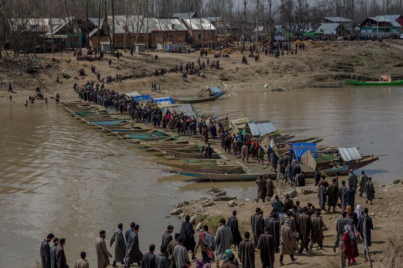 Kashmiri villagers cross a temporary bridge made by lining up boats to make way for people to cross a river to attend funeral of Shabir Ahmad, a suspected rebel killed in Awantipora, 30 kilometres (18 miles) south of Srinagar. Dar Yasin / AP Photo