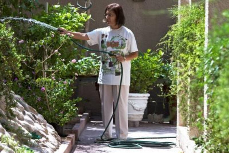 Jumeira, October 4, 2010 - Deena Motawala waters the plants in her home garden in Jumeira, Dubai, October 4, 2010. Her garden stretches around three sides of her villa. Motawala is one of the first members of the Royal Horticultural Society in Dubai. (Jeff Topping/The National) 