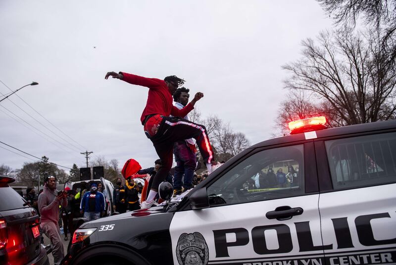 A man stomps the windshield of a police vehicle as people to protest against the death of a man in police firing in Brooklyn Centre, Minnesota. AFP