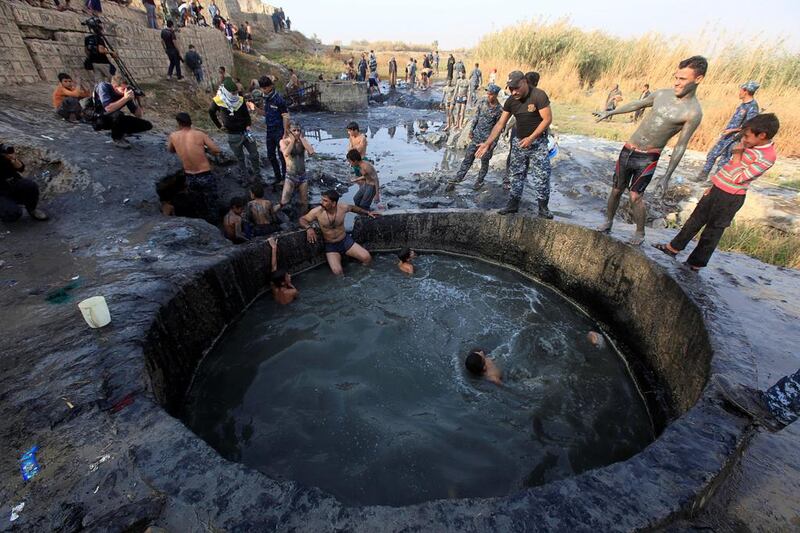 Civilians and Iraqi security forces swim in a sulphur pond in Hammam Al Ali, south of Mosul. Alaa Al Marjani / Reuters