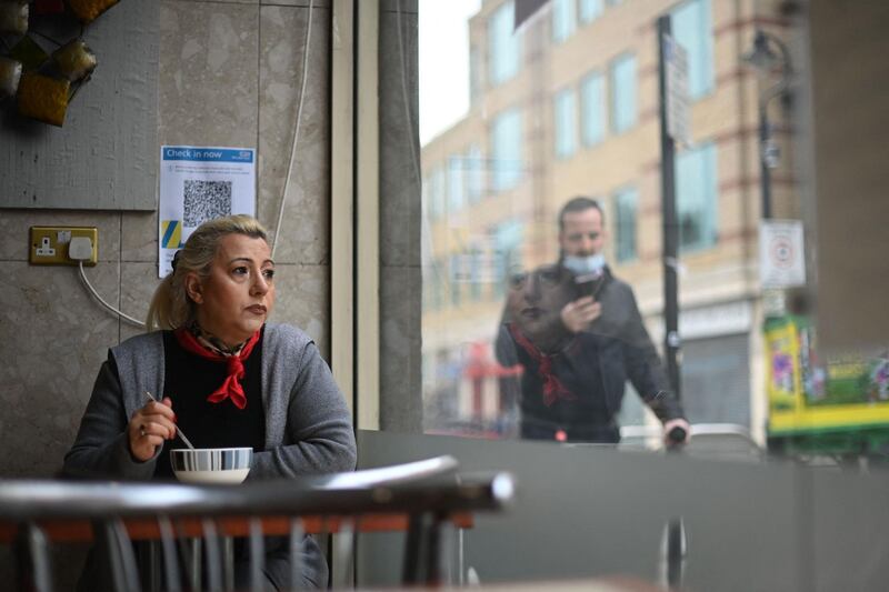 A customer looks out the window at Barbarella's cafe in London as Covid-19 lockdown restrictions ease across the country. AFP
