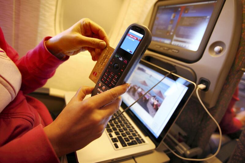 TRIVANDRUM, INDIA - DECEMBER 08:  A woman is working with a notebook and makes a telephone call, paid by credit card on board of a Emirates Airline passenger jet on December 08, 2009 in Trivandrum, India. Since some month its new that travelers can use the ICE System, internet by LAN, write emails or doing office work or internet shopping with a computer and a screen integrated in the seats.As well its possible to make telephone calls (Photo by EyesWideOpen/Getty Images)