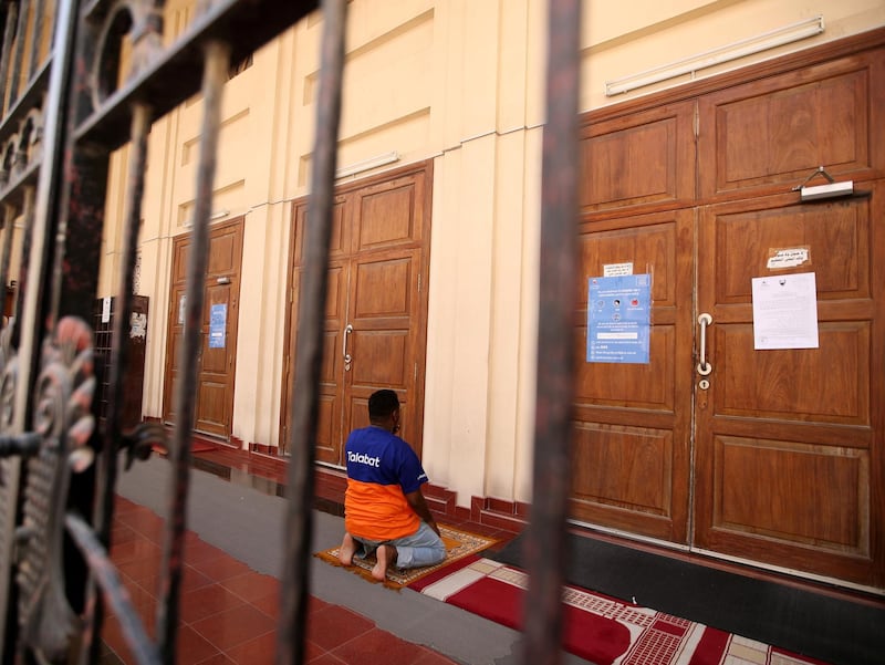 A man prays outside of a closed mosque, as Friday prayers were suspended following the spread of the coronavirus, in Isa Town south Manama, Bahrain. Reuters