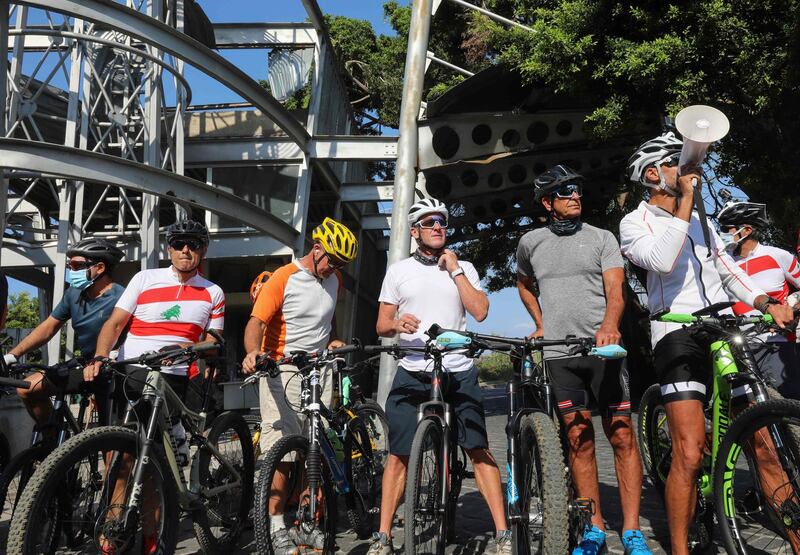 US former professional cyclist Lance Armstrong and Lebanese sportsman Maxime Chaya along with local and foreign cyclists pose for a picture prior to "Bike for Beirut" charity tour at the site of the August 4 port explosion.  AFP