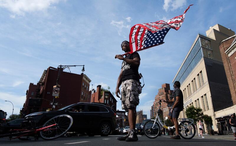 A man holding an American flag helps block traffic on Seventh Avenue during a Black Lives Matter protest against police brutality as part of the larger public response sparked by the recent death of George Floyd, an African-American man who was killed last month while in the custody of the Minneapolis police, in New York.  EPA